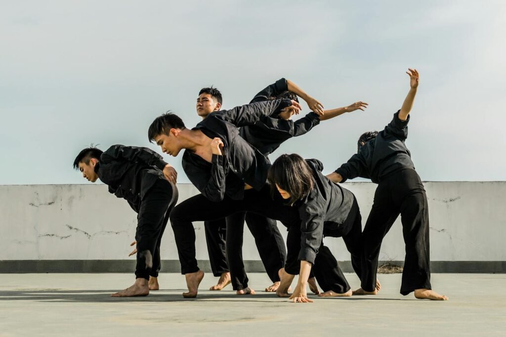 A group of adults performing dynamic contemporary dance on a rooftop.