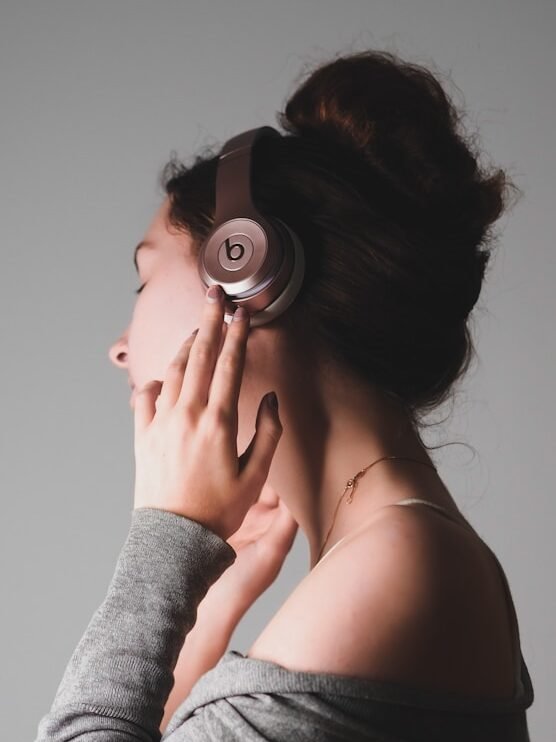 woman in gray long sleeve shirt covering her face with her hands