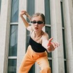 a woman in a black top and orange pants